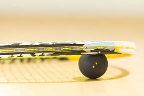 A squash ball and racket on the court at Squash Revolution squash club